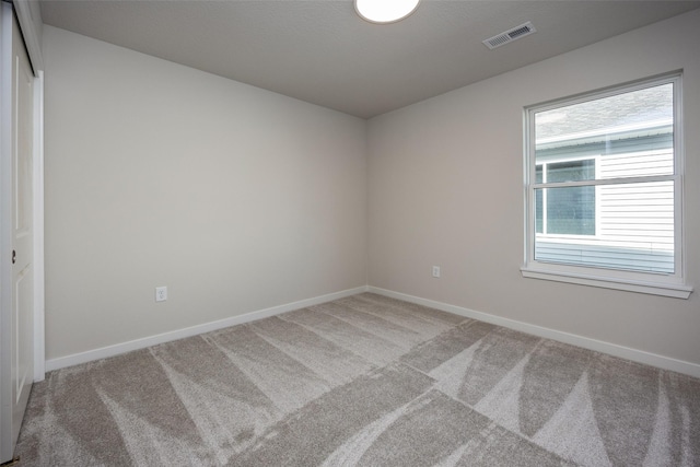 carpeted spare room featuring a healthy amount of sunlight