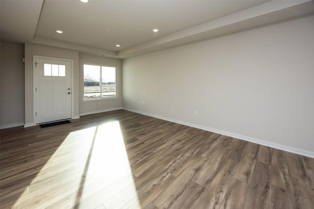 foyer with dark hardwood / wood-style flooring and a tray ceiling