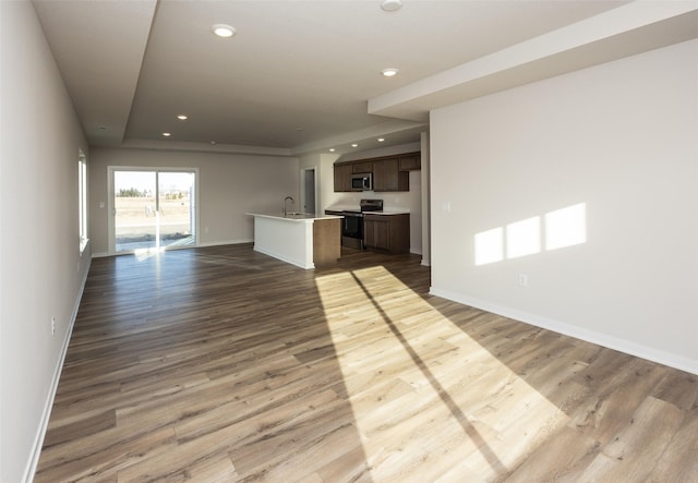 unfurnished living room with hardwood / wood-style flooring and sink