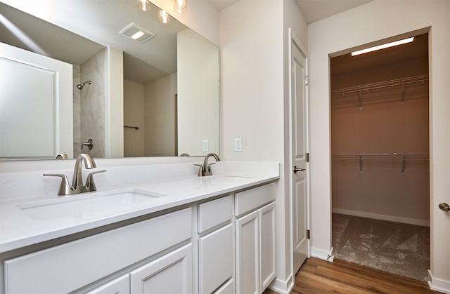 bathroom featuring hardwood / wood-style flooring, vanity, and a shower