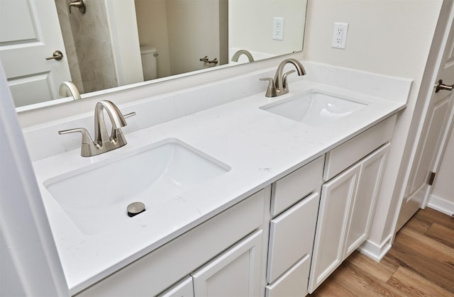 bathroom with hardwood / wood-style floors, vanity, and toilet