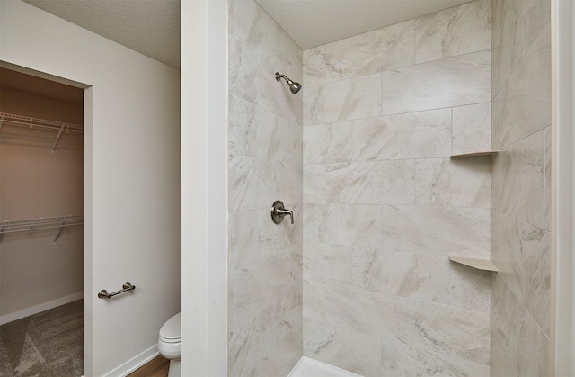 bathroom with toilet and tiled shower