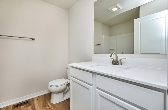 bathroom featuring a shower, hardwood / wood-style floors, vanity, and toilet