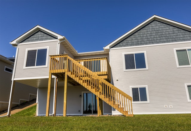 rear view of property with a wooden deck and a lawn