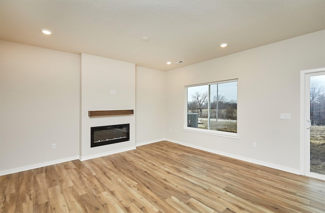 unfurnished living room featuring a healthy amount of sunlight and light wood-type flooring