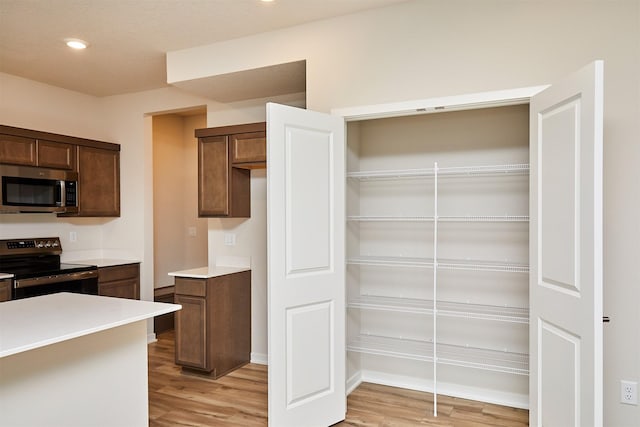 kitchen with stainless steel appliances and light hardwood / wood-style floors