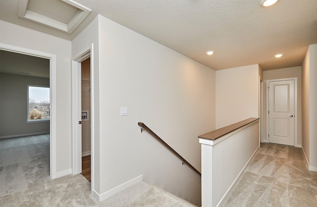 stairway featuring carpet and a textured ceiling