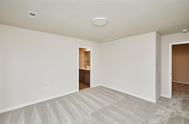 empty room featuring light carpet and a textured ceiling