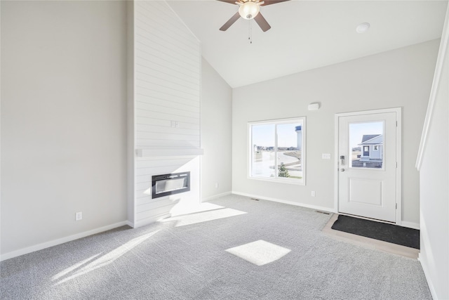 unfurnished living room with carpet, high vaulted ceiling, a fireplace, and ceiling fan