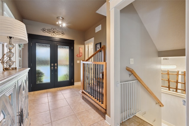 foyer entrance with french doors, visible vents, baseboards, and light tile patterned floors