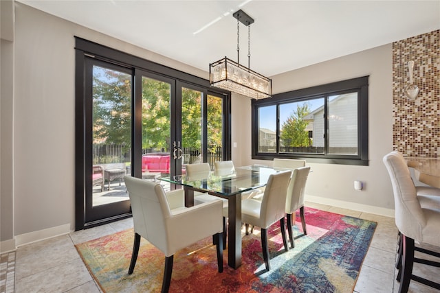 dining room with french doors, baseboards, and light tile patterned floors