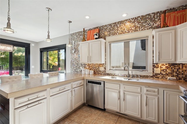 kitchen with a sink, light countertops, dishwasher, and hanging light fixtures