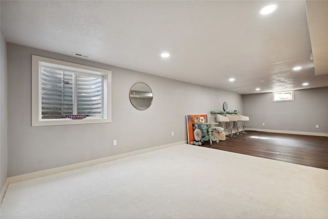 interior space with baseboards, wood finished floors, visible vents, and recessed lighting