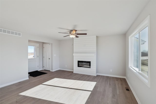 unfurnished living room featuring hardwood / wood-style flooring, a fireplace, and ceiling fan