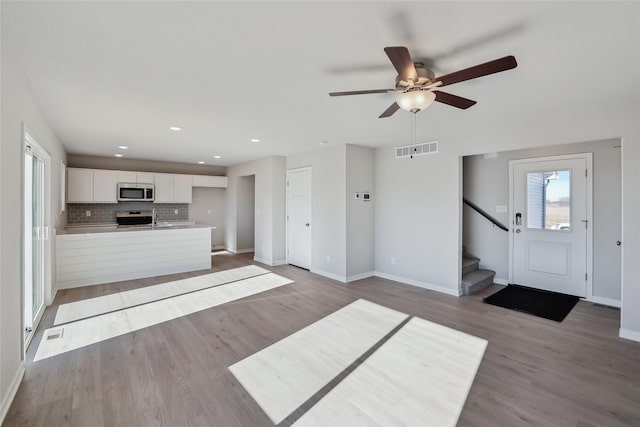 unfurnished living room with ceiling fan and light wood-type flooring