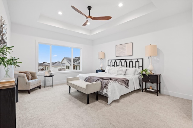 bedroom with a tray ceiling, ceiling fan, and light colored carpet