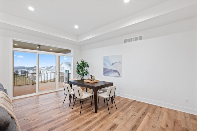 dining space with expansive windows and light hardwood / wood-style flooring