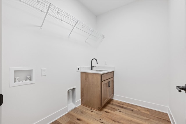 washroom with electric dryer hookup, cabinets, sink, light hardwood / wood-style flooring, and washer hookup