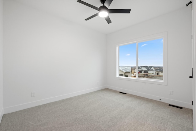 empty room featuring ceiling fan and light carpet