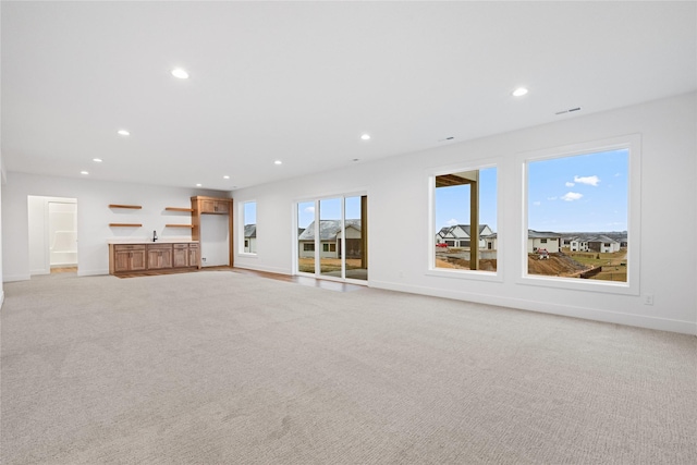 unfurnished living room with light colored carpet