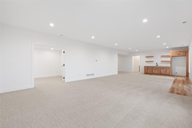 unfurnished living room with light colored carpet