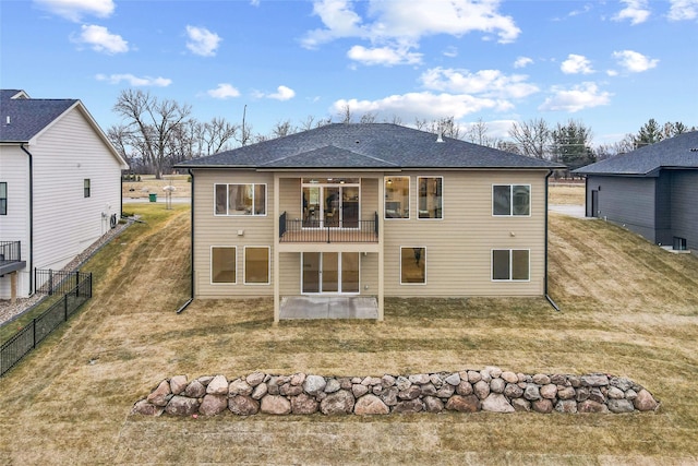 rear view of property with a lawn and a balcony