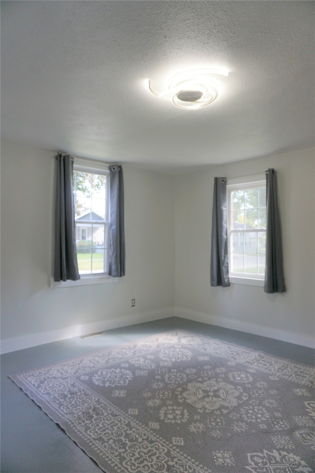 unfurnished room featuring a textured ceiling