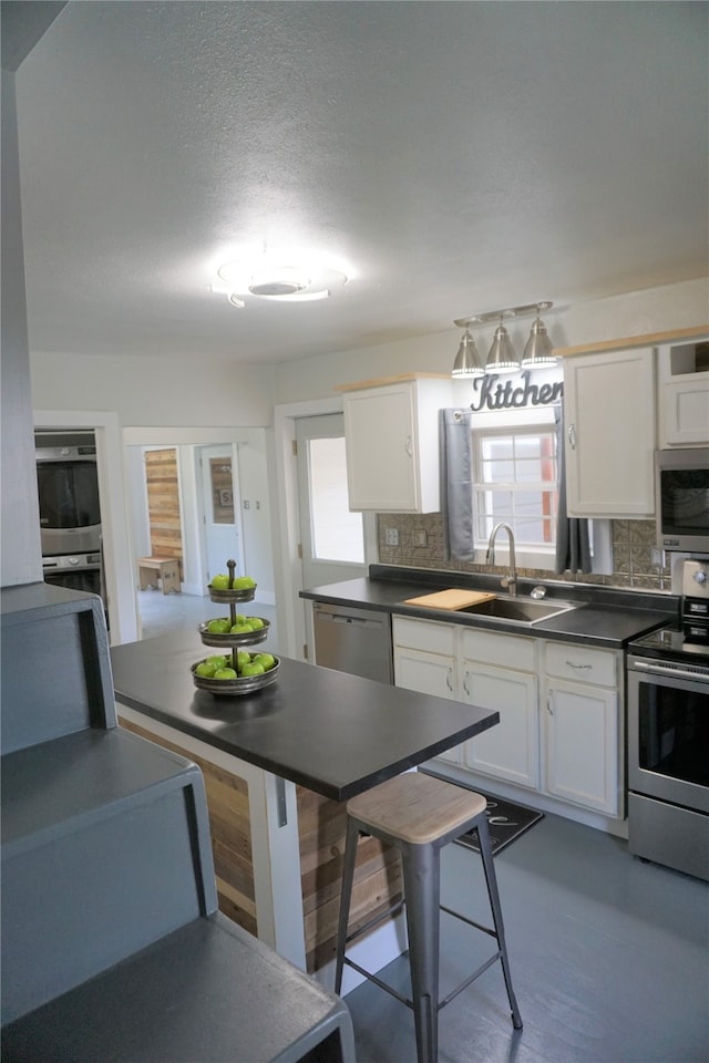 kitchen featuring white cabinets, stainless steel appliances, tasteful backsplash, and sink