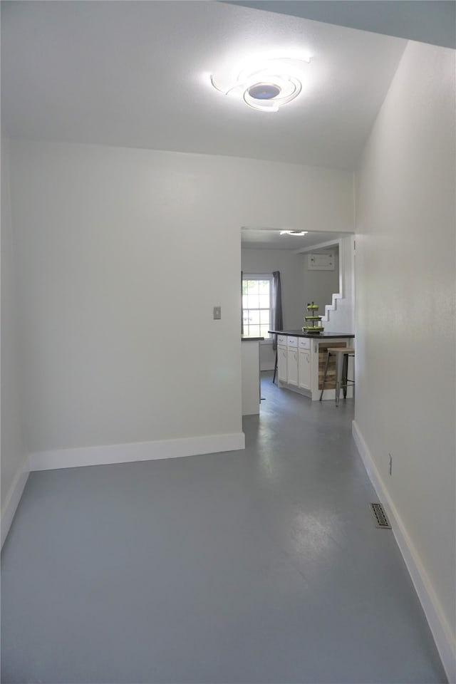 unfurnished room with concrete flooring