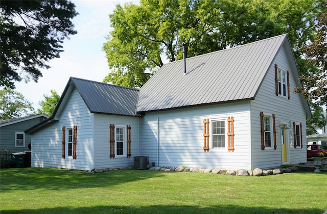 rear view of property with a yard and central air condition unit