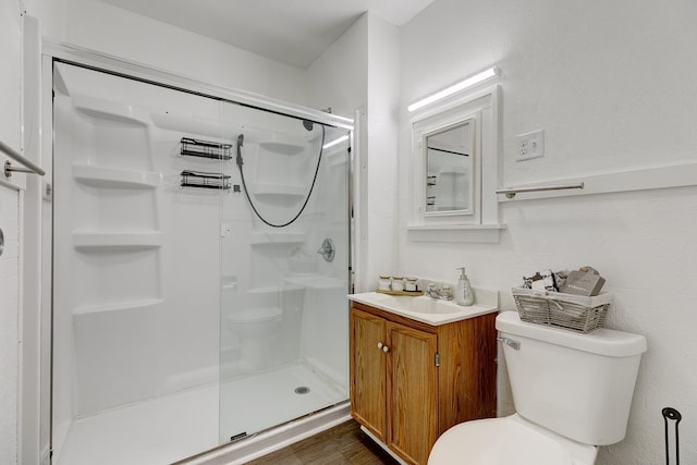 bathroom featuring vanity, toilet, hardwood / wood-style floors, and a shower with shower door