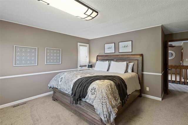 bedroom with light carpet and a textured ceiling