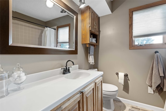 bathroom with a shower with curtain, toilet, plenty of natural light, and vanity