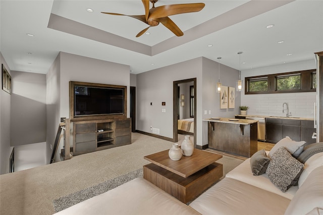 living room with ceiling fan, light carpet, and sink