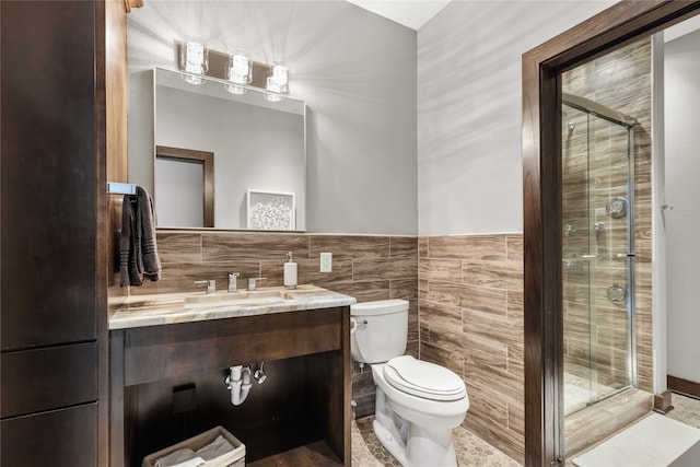 bathroom featuring toilet, tile walls, a shower with shower door, tasteful backsplash, and vanity