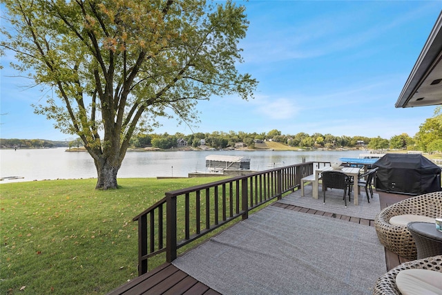 wooden deck with a grill, a yard, and a water view