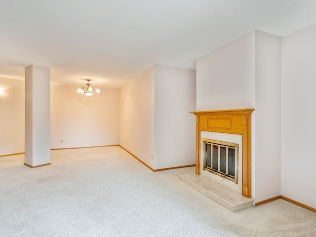 unfurnished living room featuring carpet, a high end fireplace, and a chandelier