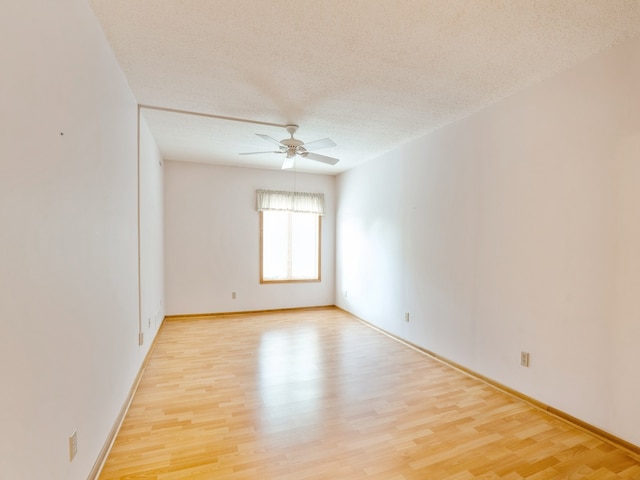 spare room featuring a textured ceiling, light hardwood / wood-style flooring, and ceiling fan