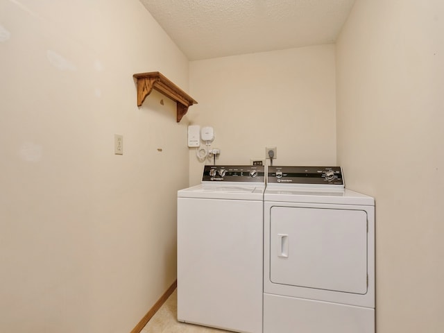 laundry room featuring a textured ceiling and washer and clothes dryer