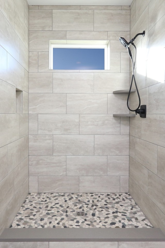 bathroom featuring a healthy amount of sunlight and tiled shower