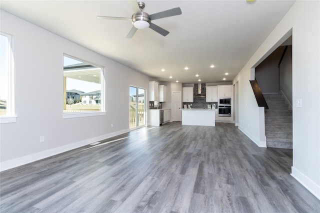 unfurnished living room with hardwood / wood-style flooring and ceiling fan