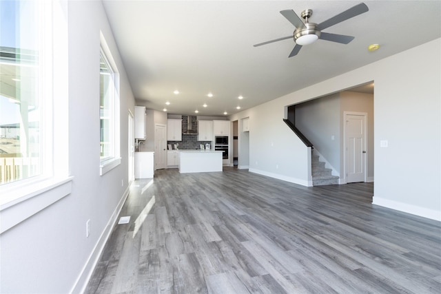 unfurnished living room with ceiling fan and hardwood / wood-style floors