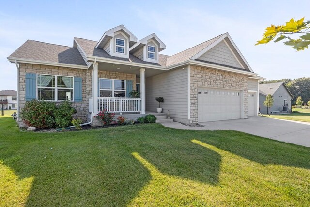 view of front of property with covered porch, a front yard, and a garage