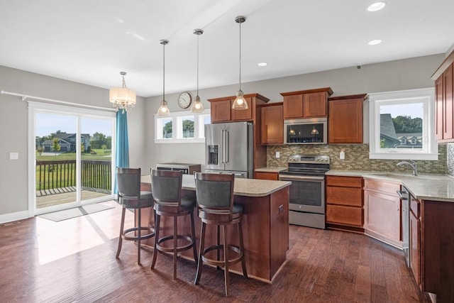 kitchen with tasteful backsplash, appliances with stainless steel finishes, light countertops, and a sink