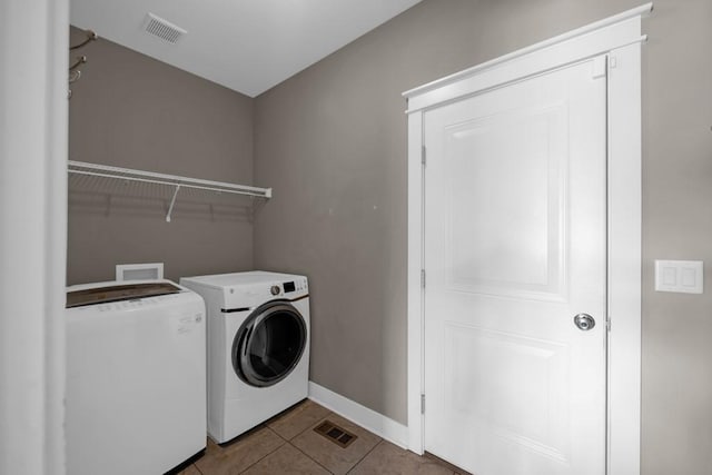 clothes washing area with tile patterned flooring, laundry area, visible vents, and separate washer and dryer