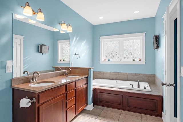 bathroom with double vanity, a sink, a bath, and tile patterned floors