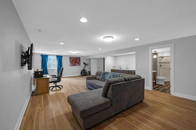 living room with recessed lighting, baseboards, and light wood finished floors