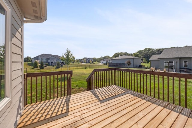 wooden deck featuring a fenced backyard, a residential view, and a yard