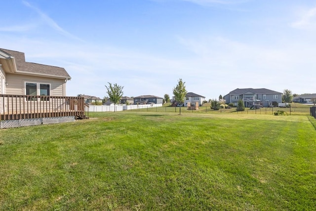 view of yard with a residential view, fence, and a deck