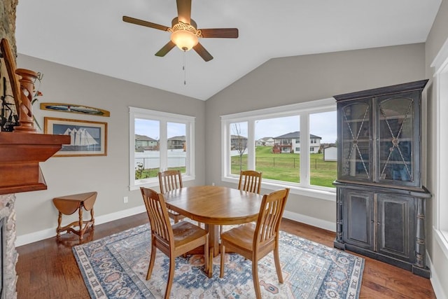 dining space with lofted ceiling, ceiling fan, baseboards, and wood finished floors